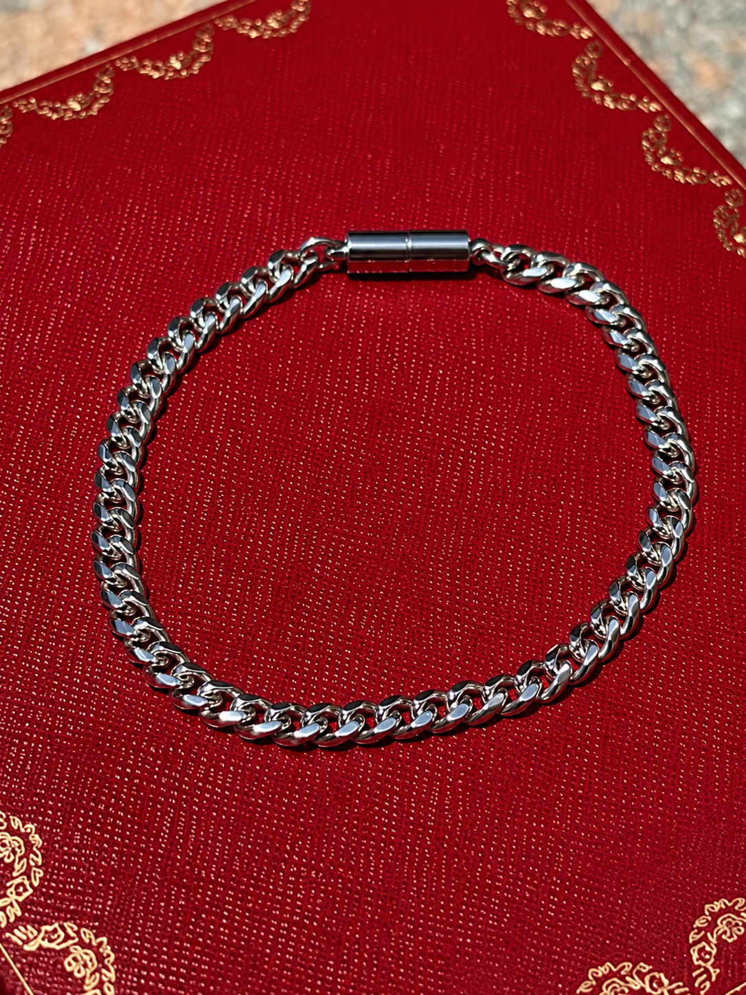 Silver cuban magnetic bracelet by Oruma on a red background